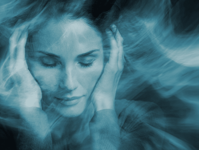 Person looking stressed at computer dealing with migraine symptoms